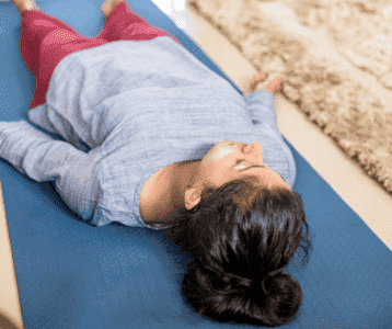 Body Scan, eine Frau liegt auf der Yoga matte, Stress abbauen ohne Sport Stressreduktion im Alltag